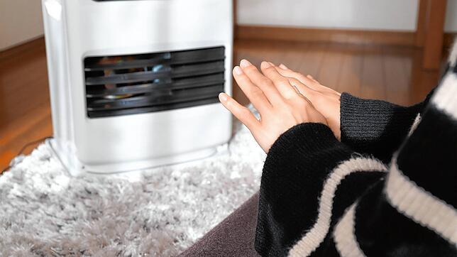 Eine Frau wärmt sich die Hände an einem elektrischen Heizlüfter. Vor dem Hintergrund einer drohenden Gasknappheit setzen viele ...