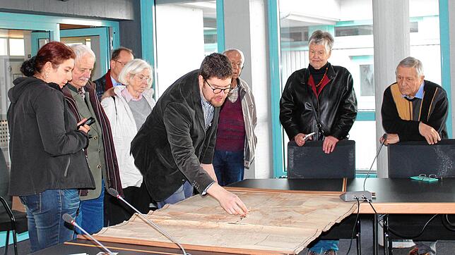 Der Leiter des Stockacher Stadtarchivs, Johannes Waldschütz, mit Besuchern beim Tag der Archive: Auch alte Pläne werden dort aufbewahrt. ...