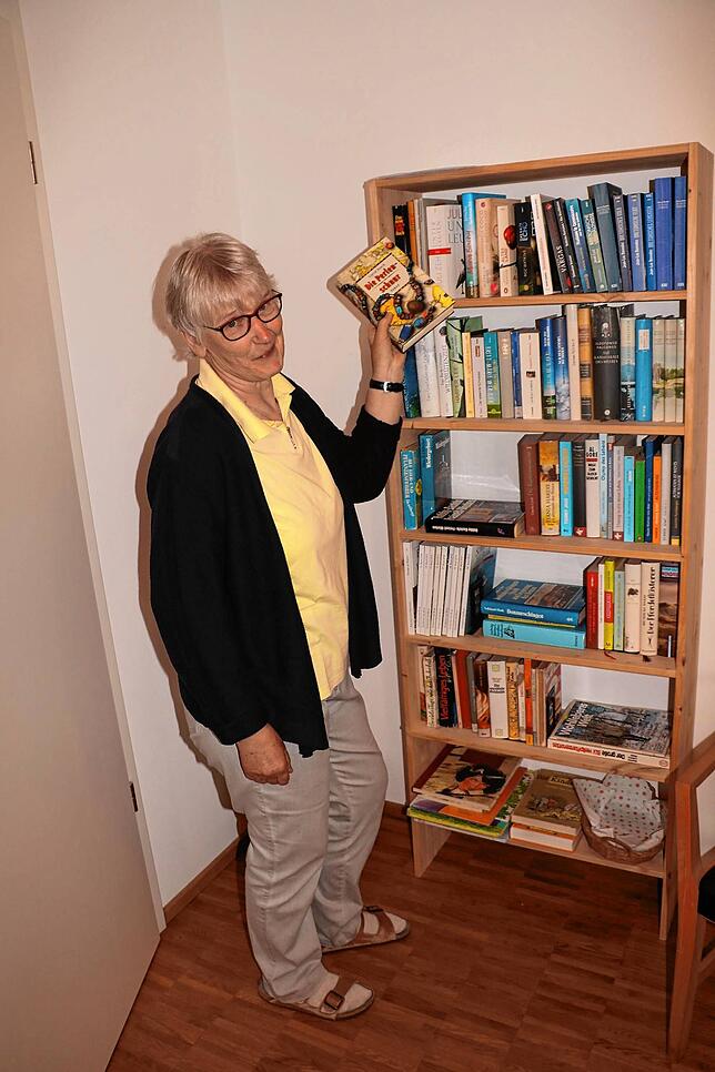 Gabriele Reydt am Bücherregal in der Gemeinschaftswohnung. Hier darf sich jeder Lektüre ausleihen.
