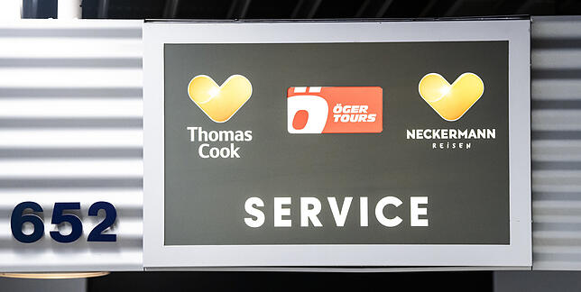 Die Logos von Thomas Cook, Öger Tours und Neckermann Reisen an einem Flughafen-Service-Schalter. Familie Liebhardt hatte die Reise mit ...