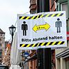 Ein Hinweisschild mit der Aufschrift &bdquo;Bitte Abstand halten&ldquo; hängt an einer Straßenlaterne in der Fußgängerzone von Rottweil. ...