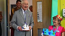 König Charles III. hält eine Krone, die die vierjährige Arielle Bayliss ihm geschenkt hat, deren Mutter Rebecca Turner Patientin ist, ...