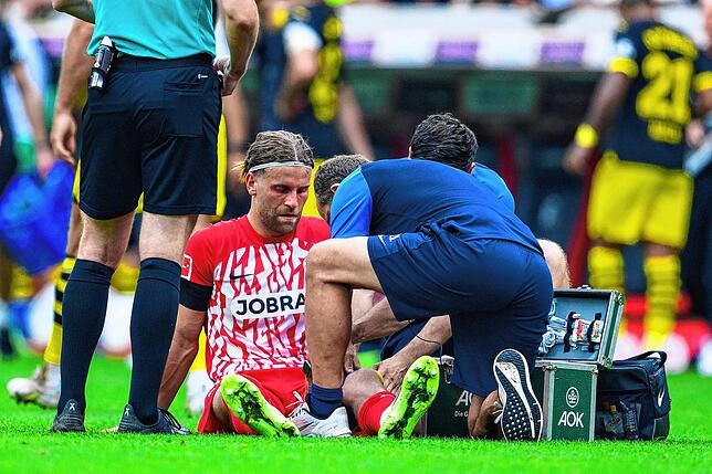 Freiburgs Lucas Höler sitzt verletzt auf dem Boden.