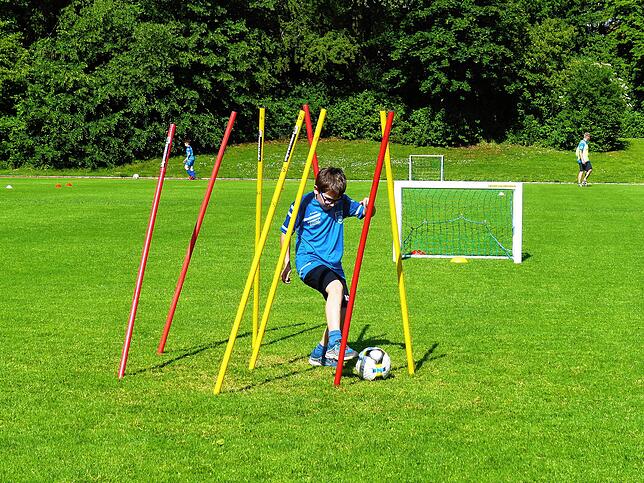 Dribbeln zwischen Stangen: Die Übungen sind darauf ausgerichtet, dass die Kinder Abstand zueinander halten können.