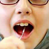 Eine Grundschülerin macht den Lolli-Test (Symbolfoto).