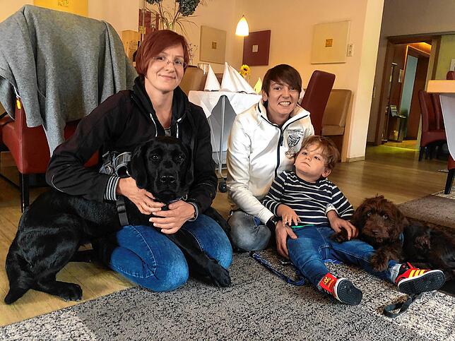 Assistenzhundetrainerin Kathrin Riedy, Vanessa Falbo und Nick mit den Hunden Muffin und Nandi.