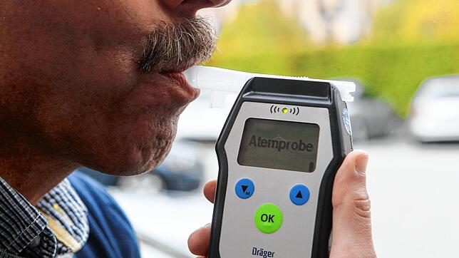 Symbolbild Alkoholtest. Dumm gelaufen ist es für einen Mann, der betrunken mehrere Autos beschädigt hat. Er ist nun seinen Führerschein los.