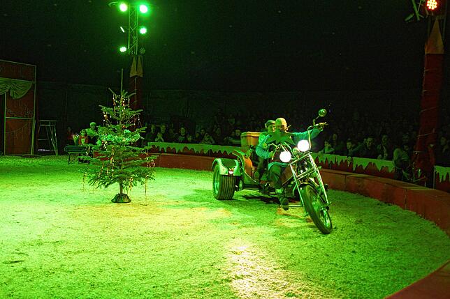 Grandelbart kommt auf einem Motortrike in die Manege.
