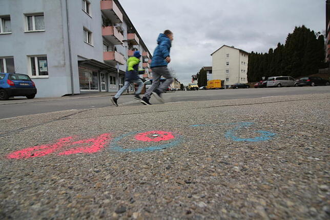 Hauptmotiv: Protagonisten der Geschichte mit Blick in die Straße, sodass ein Teil des Straßenzugs zu sehen ist.