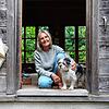 Anne Donath sitzt mit ihrem Hund im Eingang ihres Blockhauses in Steinhausen.