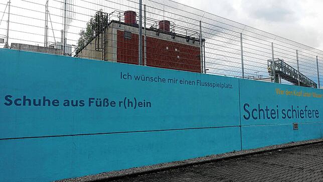 Texte über den Rhein finden sich auf einer von Ruth Loibl gestalteten Mauer am Rheinufer beim Wasserkraftwerk. Foto: Roswitha Frey