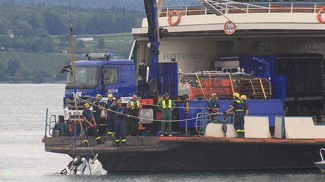 Die Wrackteile des abgestürzten Flugzeuges werden aus dem See gehoben.