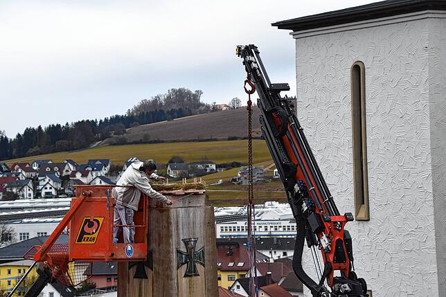 Andreas Mauch misst nach, damit das Nest wirklich mittig auf dem Denkmal sitzt.