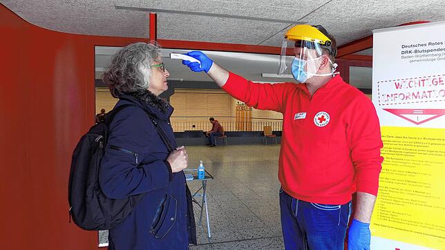 Alexander Sieber misst bei einer Blutspenderin in Murg Fieber. Das Bild entstand im März 2020.