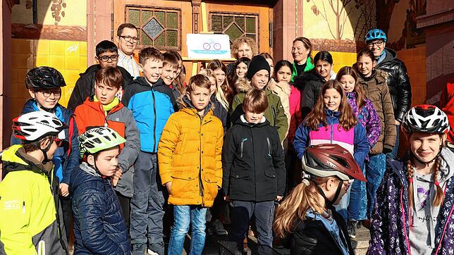 Schulleiterin Kerstin Schuldt hält das Schild &bdquo;Fahrradfreundliche Schule&ldquo; hoch. Mit im Bild Schüler der Klasse 5a sowie ...