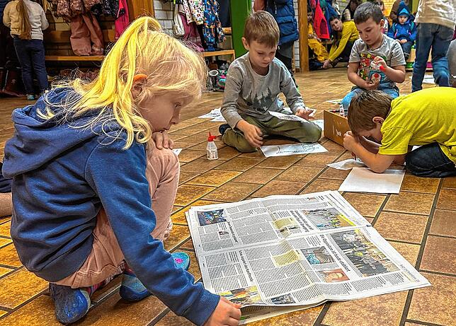 Lea, Leonid, Enrico und Jan sind bei der Aufgabe richtig in die Zeitung vertieft. Wenn sie ein Foto gefunden haben, schneiden sie es aus ...