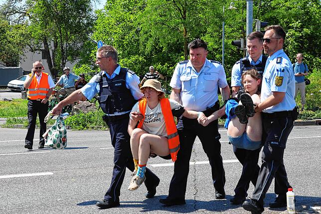 Polizisten tragen die beiden Frauen von der Letzten Generation davon.