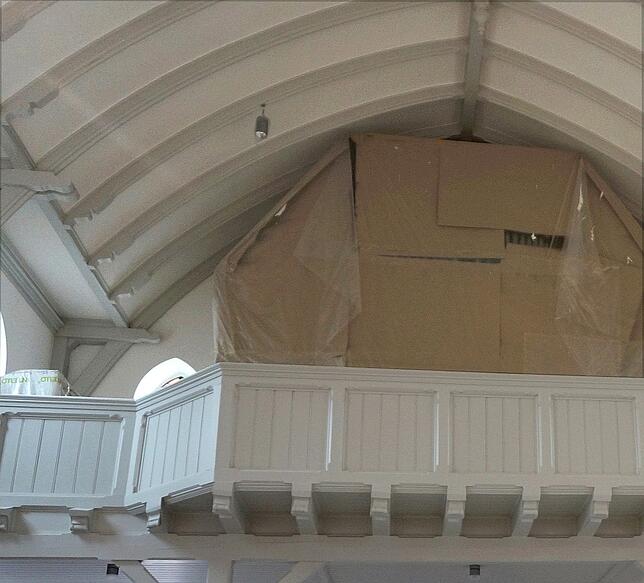 Blick auf die Empore der „neuen“, in weiß-hellgrau gestrichenen Christuskirche mit der noch „eingepackten“ Orgel.