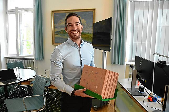 Christoph Stolz hält den Stein in Händen, den er von den ehemaligen Kollegen in Deizisnau als symbolischen Baustein für sein ...