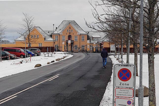 Ein Mann geht auf einer Straße in Richtung des Aufnahmezentrums Sandholm.
