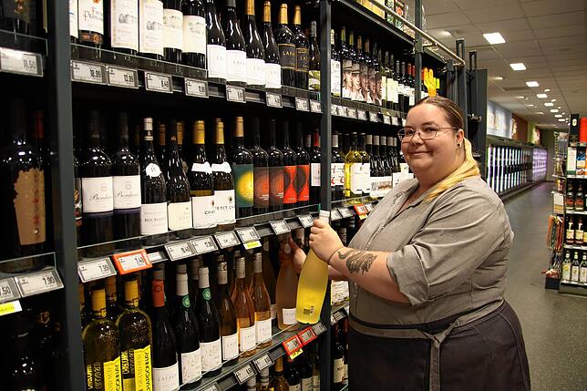 Lea-Denise Baber räumt das Spirituosen-Regal ein, ihr Arbeitsplatz ist in dieser Woche die Bäckerei.