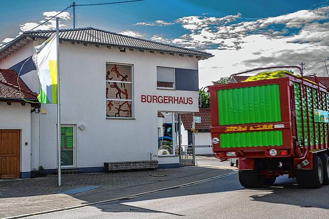 Ein Landwirt bringt die Ernte ein und nimmt den Weg durch Altheims Mitte vorbei am Bürgerhaus.
