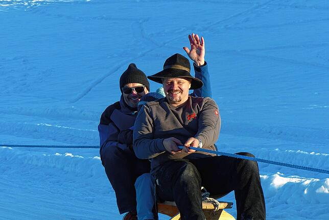 Der Hürrlinger Ortsvorsteher, Christoph Wehle, freut sich über die Talfahrt mit Herbert Duttlinger auf dem Skischlitten.