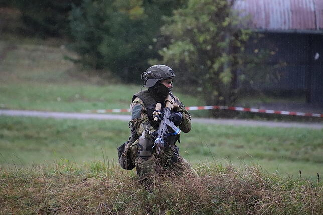 Ein SEK-Soldat mit Sturmgewehr sichert in der Hocke.