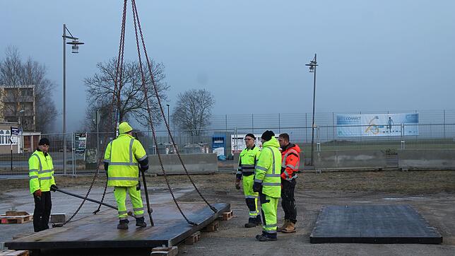 Männer vom Bauhof verlegen den Untergrund für die Eisbahn und nivellieren den Sitz der einzelnen Planken ein. Bild: Reiner Baltzer