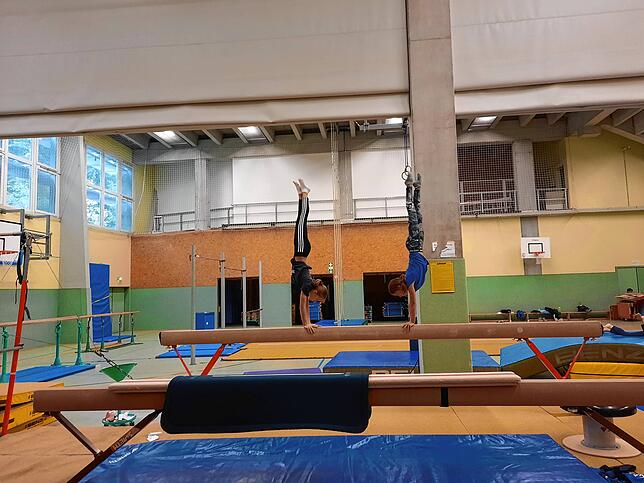 Zwei Turnerinnen der Turnerschaft Friedrichshafen am Schwebebalken: Der Verlust der großen und teilbaren Turnerhalle unter der Tribüne ...
