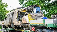 Ein verladener Zug Wagon steht an der Unfallstelle, an der ein Regionalzug entgleist ist.