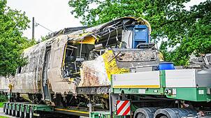 Ein verladener Zug Wagon steht an der Unfallstelle, an der ein Regionalzug entgleist ist.