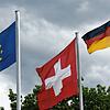 Die europäische, die Schweizer und die deutsche Flagge sind am Grenzübergang bei Weil am Rhein zu sehen.