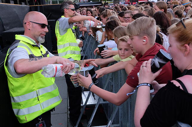 Die Sicherheitskräfte halfen den teils jungen Fans bei der Hitze, genügend Wasser zu trinken.