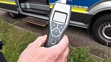 Ein Polizist hält einen Alcomaten in der Hand. (Symbolbild) In Wehr hat die Polizei zwei betrunkene Autofahrer aus dem Verkehr gezogen.