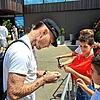 Nationalspieler David Raum steigt als erster aus dem Bus und gibt ein paar jungen Fußballfans Autogramme.