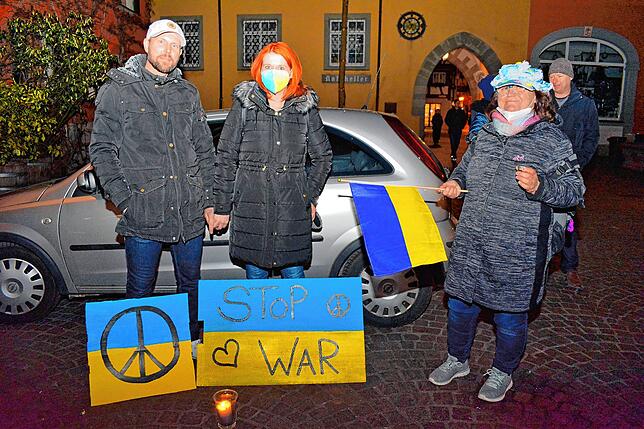 Ingo und Sarah Schneider fordern mit selbstgemachten Schildern in den ukrainischen Farben ein Ende des Krieges, Brigitte Jahn (rechts) ...