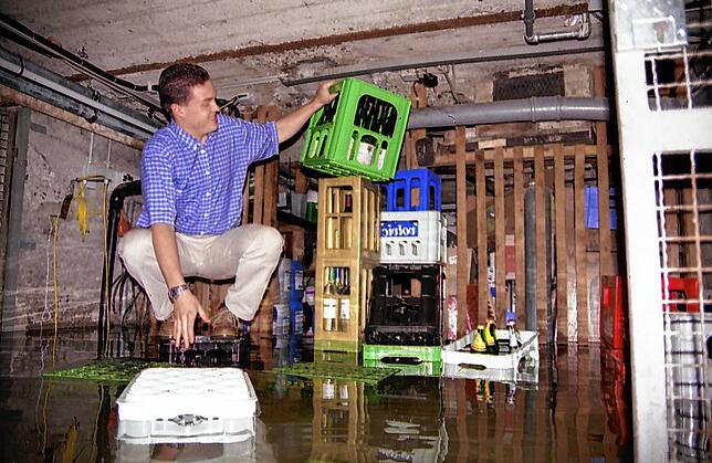 Christoph Specht ist hier 1999 im überschwemmten Keller des Ludwigshafener Adlers. Auf einem Getränkekasten behält er trockene Füße.