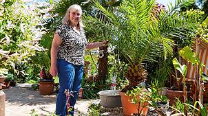 Margret Rupp in Urlaubsstimmung unter Palmen. Sie hat sich an der Raiffeisenstraße ein kleines Paradies geschaffen und öffnet es während ...