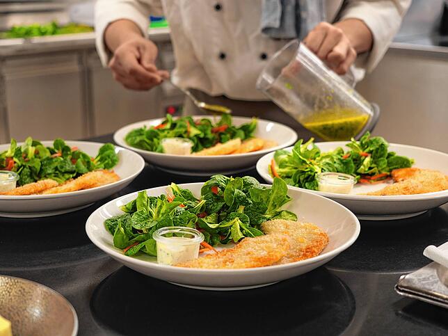 Panierte Sellerieschnitzel an Feldsalat und karamellisierten Walnüssen – so bereitet der Indonesier Barnes Dandi Malan die Vorspeise zu.