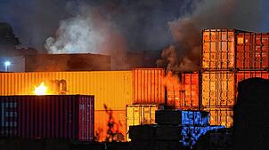Feuerschein ist bei einem Brand in einem Industriegebiet im Hamburger Hafen zu sehen.