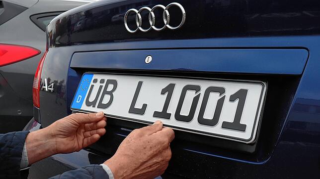 Ein Autofahrer hält sich sein Kennzeichen ans Heck. Seit Februar gibt es wieder die Überlinger ÜB- und das Tettnanger TT-Kennzeichen ...
