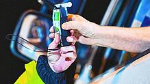 (Symbolbild) Ein Polizist reicht einem Fahrer ein Alkoholmessgerät. Auch in Singen ertappten Beamte am Fasnachtssamstag zwei Alkoholsünder.
