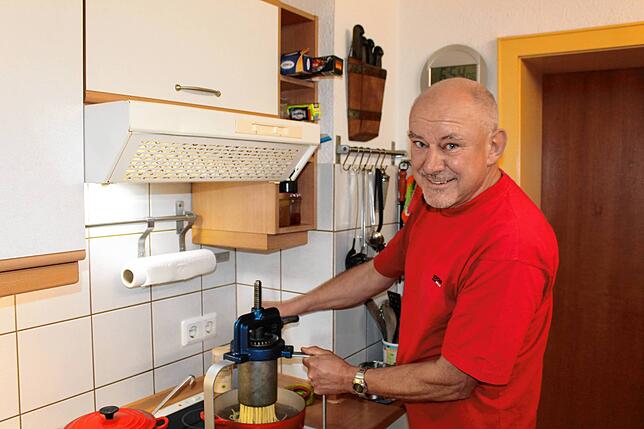 Martin Strangfeld triebelt den Teig mit der Knöpfle-Maschine in den Topf mit dem kochenden Wasser.