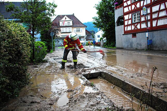 Die Einsatzleute der Feuerwehren und Technische Betriebe beseitigen den Schlamm, verursacht durch Hochwasser in Bohlingen.