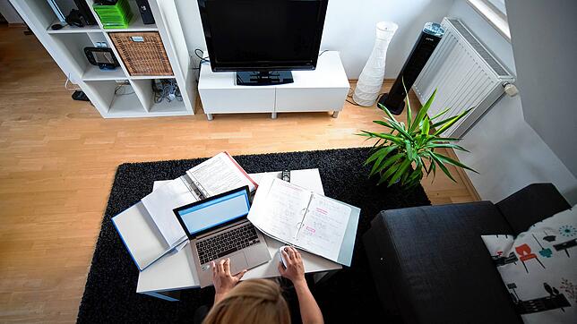Eine Frau arbeitet in einem Wohnzimmer an einem Laptop im Homeoffice. Viele Unternehmen schicken ihre Mitarbeiter ins Homeoffice, um die ...