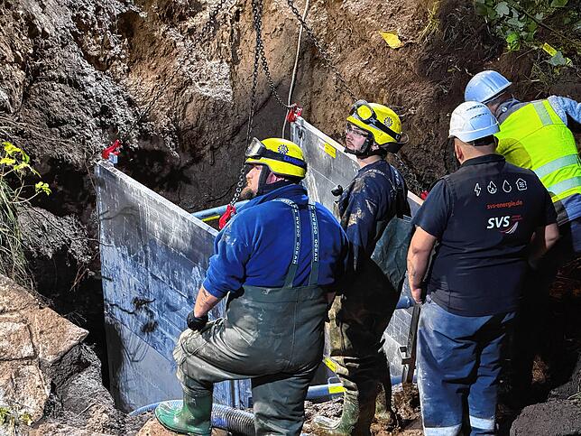 Die Einsatzkräfte arbeiten in der Baugrube – vor Ort rechnet man damit, dass die Wasserversorgung am Samstagmorgen wieder vollständig ...