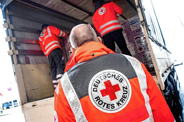Mitarbeiter des Deutschen Roten Kreuzes (DRK) verladen an einer Halle am Flughafen BER Hilfsgüter für die vom Erdbeben betroffenen ...
