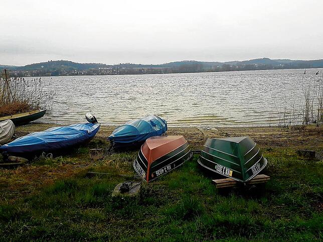 Umgedrehte Boote liegen am Ufer in einer kleinen Bucht.