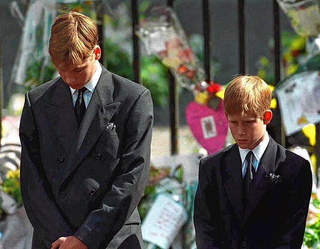 Mit gesenktem Köpfen verfolgen Prinz William (l) und Prinz Harry wie der Sarg mit der Leiche ihrer Mutter nach der Trauerfeier aus der ...